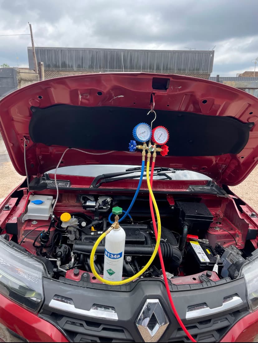 Manifold gauge set on a vehicle engine bay during a regas