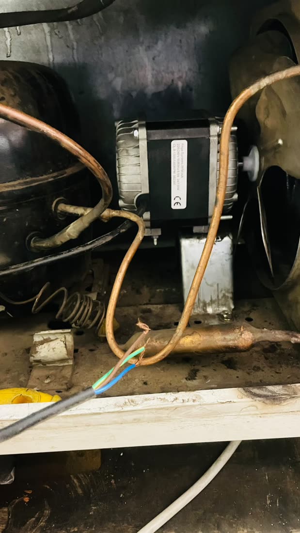 Compressor and fan motor exposed during a repair
