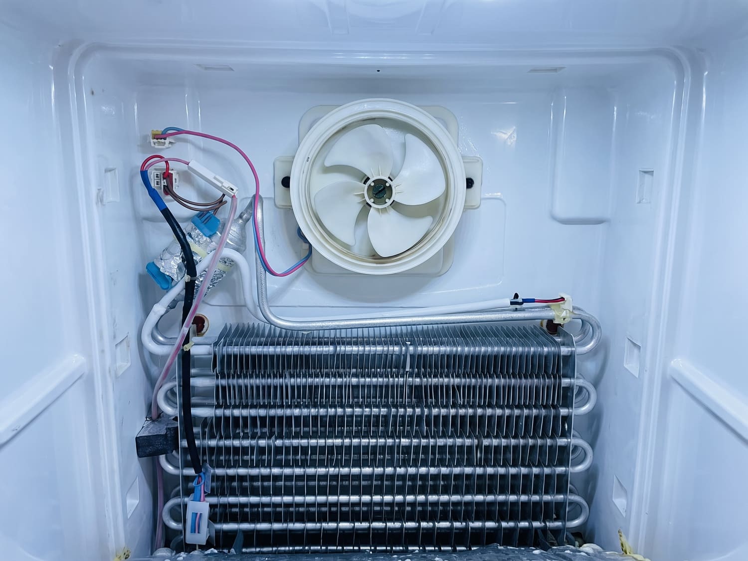 Internal fan and wiring inside a commercial fridge unit