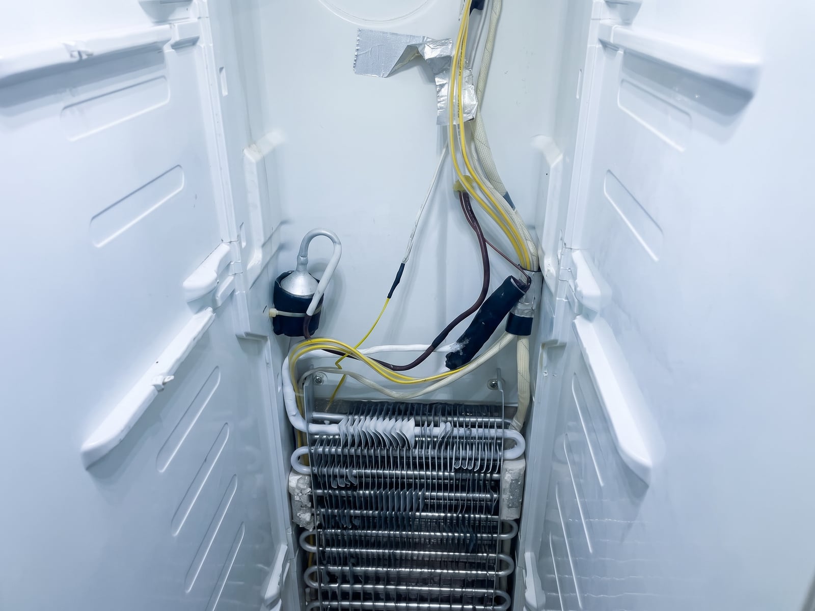 Evaporator coil exposed during a fridge repair